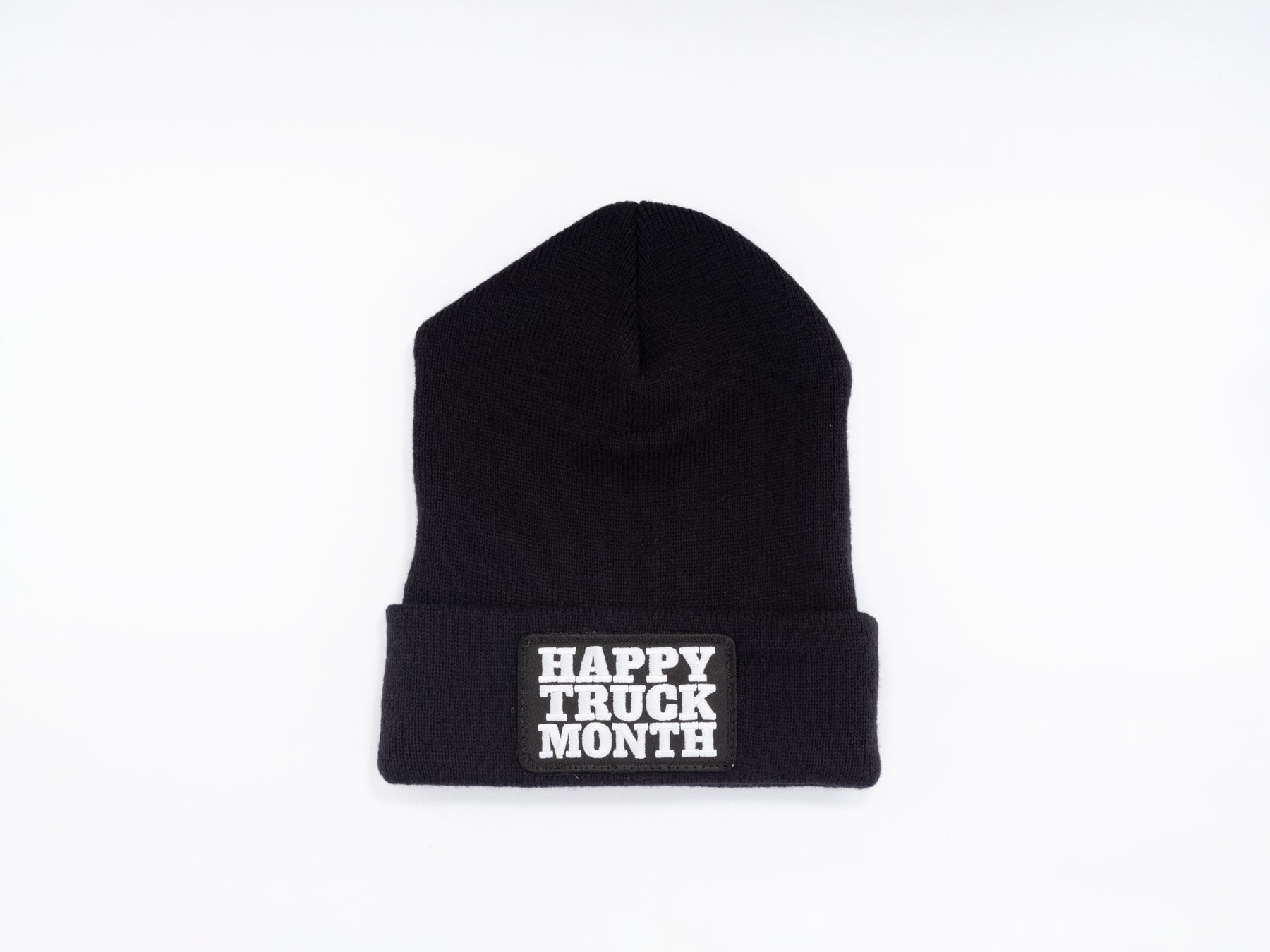A black knit beanie with a folded brim featuring bold white text that reads HAPPY TRUCK MONTH against a plain white background.