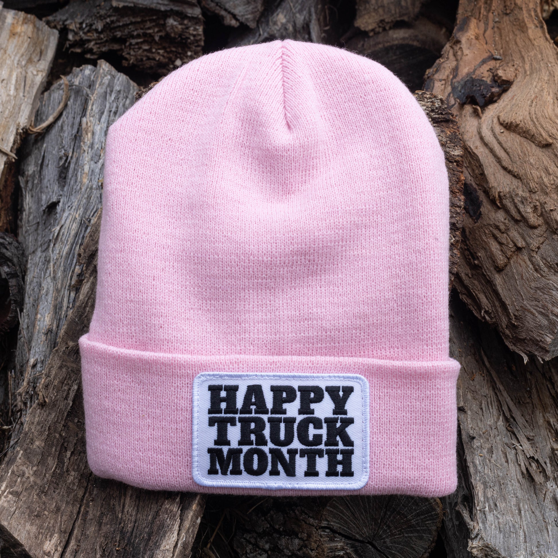 A pink beanie with a patch on it.