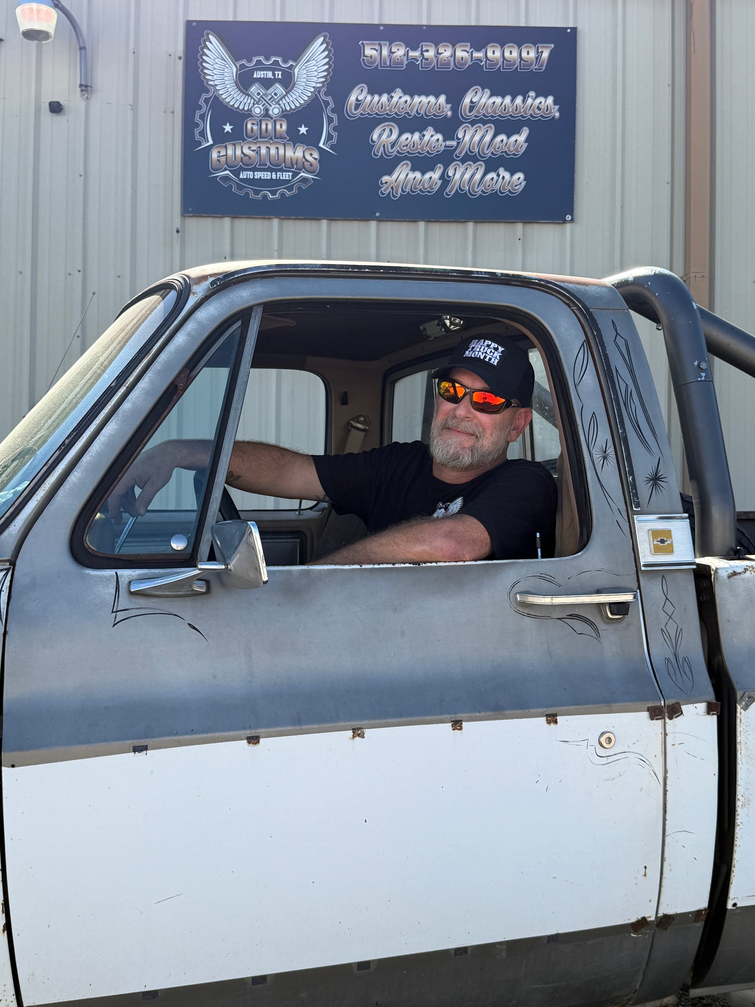 Man in pickup truck in driver's side window with sunglasses. 